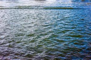 Water surface with waves and ripples and the sunlight reflecting photo