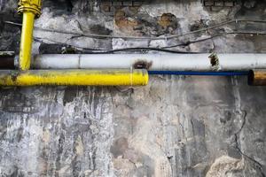 Wall in a steel mill with clear signs of use, cracks and pipes. High resolution background. photo