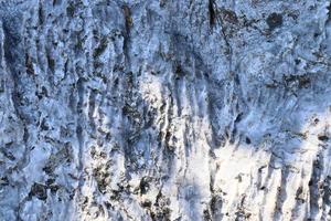 Close up view at a natural limestone wall in the mountains. photo