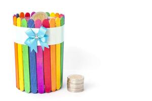 The invention and decoration Piggy bank from colorful popsicle sticks isolated on white background. photo