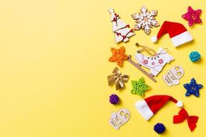 Top view of Christmas decorations and Santa hats on yellow background. Happy holiday concept with copy space photo