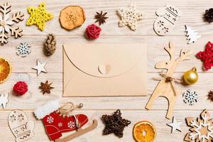 Top view of envelope on festive wooden background. Christmas toys and decorations. New Year time concept photo