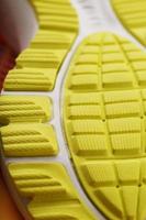 primer plano de la banda de rodadura de una zapatilla amarilla, el patrón texturizado de la suela. foto