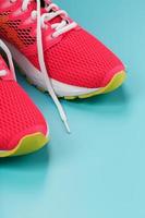 Pink sports sneakers for running on a blue background with free space. photo