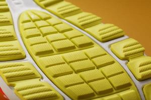 Textured design of the sole of the Tread of a sneaker in yellow Macro. photo