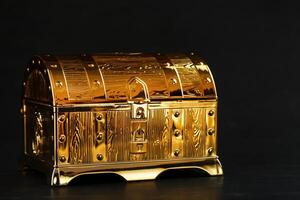 Gold treasure chest on a black textured background. photo