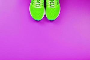 Green running shoes on a purple background. photo