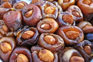 Close-up dried dates palm fruit without seed and fill with almonds inside photo