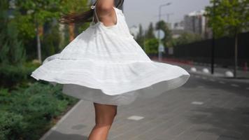 Woman in a flowy white dress walking on the street video