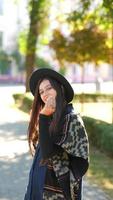 Pretty woman wearing a hat and heavy coat posing on the street video