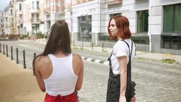 Women friends talking and walking on the sidewalk video