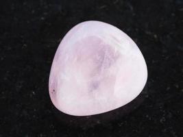 piedra de gema de cuarzo rosa pulida en la oscuridad foto