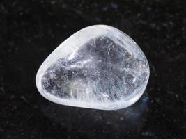 piedra preciosa de cristal de roca pulida sobre fondo oscuro foto