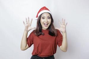 A shocked Asian Santa woman with her mouth wide open isolated by white background. Christmas concept. photo