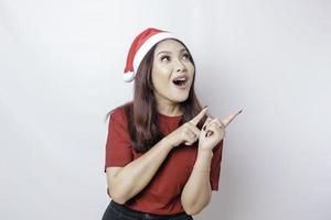 A shocked Asian Santa woman is showing her phone isolated by white background. Christmas concept. photo