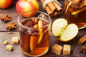 sidra de vino caliente en tazas de vidrio con canela, anís y manzanas. el concepto de la coctelería. foto