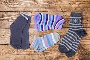 Women's socks are gray high and short colored striped on a wooden background. photo