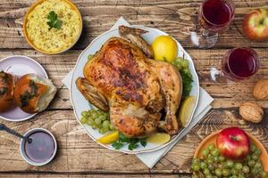 Baked chicken, mashed potatoes and wine glasses for dinner on the festive table. photo