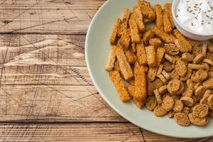 Croutons of grain bread with spices in the dishes. Wooden background. Copy space photo