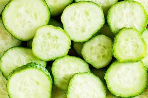 Background of fresh round pieces of cucumber. Close-up. photo