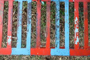 iron trellis with red and blue paint that has peeled off photo
