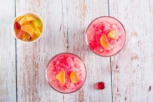 Sweet homemade shaved ice with syrup and marmalade in glasses on the table. Top view photo