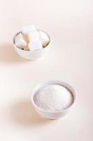 azúcar granulada y terrones de azúcar en tazones. elegir entre tipos de azúcar. vista vertical