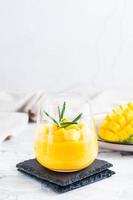 Smoothies from fresh ripe mango in glasses on the table. Homemade Dessert. Vertical view photo