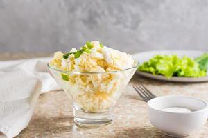 Homemade potato salad with egg and green onions in a bowl on the table photo