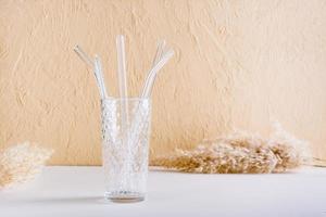 pajitas reutilizables de vidrio para bebidas y cepillo de limpieza en un vaso. estilo de vida sostenible. foto