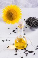 Sunflower seeds and oil in a bottle on the table. Harvest and organic products. Vertical view photo