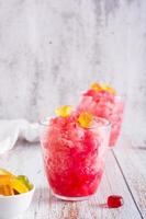 Sweet homemade shaved ice with syrup and marmalade in glasses on the table. Vertical view photo