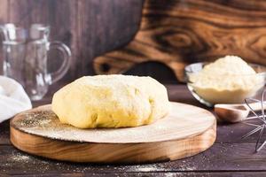 Ready raw dough for baking mexican tortillas on the board on the table. Homemade pastries photo