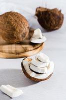 Pieces of ripe coconut on the table. Tropical fruits. Natural source of antioxidants. Vertical view photo