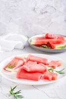 Watermelon popsicle and pieces of watermelon on a plate on the table. Homemade dessert. Vertical view photo