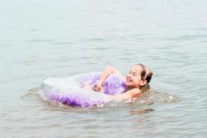 Cheerful girl holding on to an inflatable ring in the river. Local tourism. Summer vacation photo