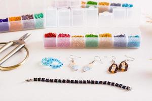 Containers with colored beads and accessories for making jewelry from beads. Needlework and handmade photo