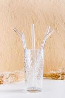 pajitas reutilizables de vidrio para bebidas y cepillo de limpieza en un vaso. estilo de vida sostenible. vista vertical foto