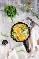 Shakshuka with poached eggs in spicy tomato pepper sauce in a frying pan. Top and vertical view