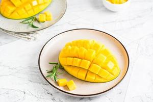 Ripe sliced mangoes on plates on the table. Tropical fruit photo