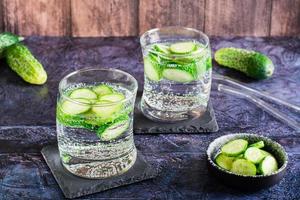 Cucumber mineral water in glasses on the table. Homemade antioxidant drinks photo