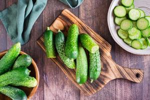 Fresh cucumbers on a cutting board on the table. Dietary organic food. Top view photo