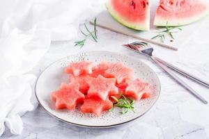 estrellas de sandía maduras en un plato sobre la mesa. refresco de verano. foto