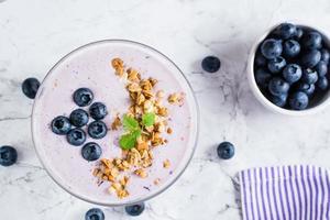 Tazón de batido con arándanos y granola. alimento dietético antioxidante orgánico. vista superior. de cerca foto