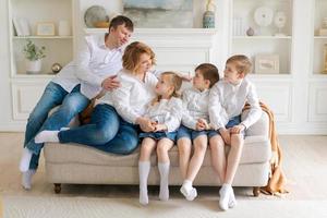 Big happy family sitting on couch in bright living room. Family portrait photo