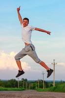 happy young man jumping in up on nature photo