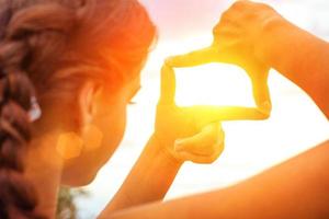 hand framing view distant over sunset photo