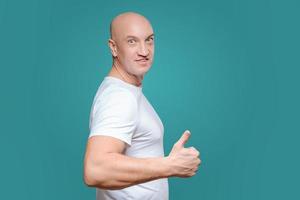 an emotional man in a white t-shirt shows with a hand gesture that everything is cool, on a Titian background photo