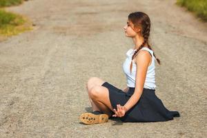 young woman sitting on the road and meditating, relax photo