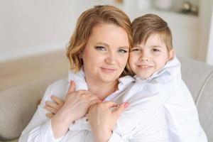 Head shot happy young woman hugging talking to little son having fun together photo